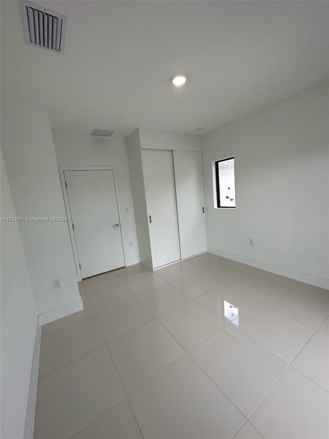 unfurnished bedroom with a closet and light tile patterned floors