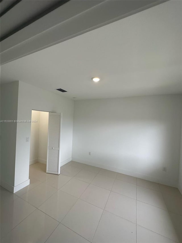 unfurnished bedroom featuring light tile patterned flooring and a closet