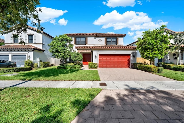 mediterranean / spanish home with a garage and a front lawn