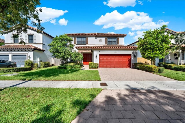 mediterranean / spanish-style home featuring a garage and a front lawn