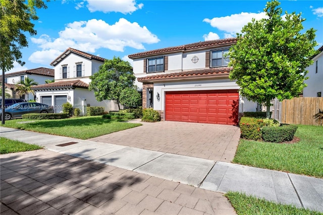 mediterranean / spanish-style house with a garage and a front lawn