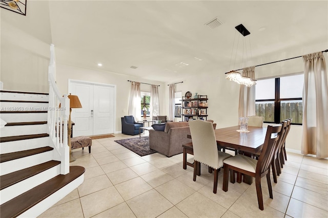 dining area with light tile patterned flooring and a notable chandelier