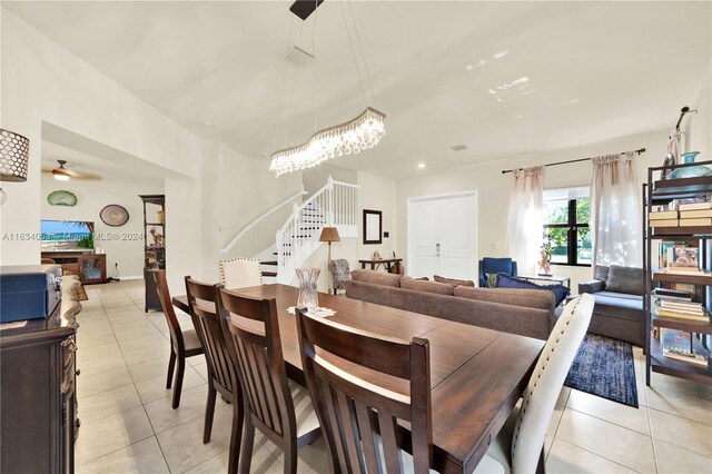 dining room with ceiling fan with notable chandelier and light tile patterned floors