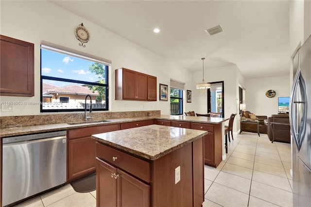 kitchen featuring light tile patterned flooring, a kitchen island, plenty of natural light, and stainless steel appliances