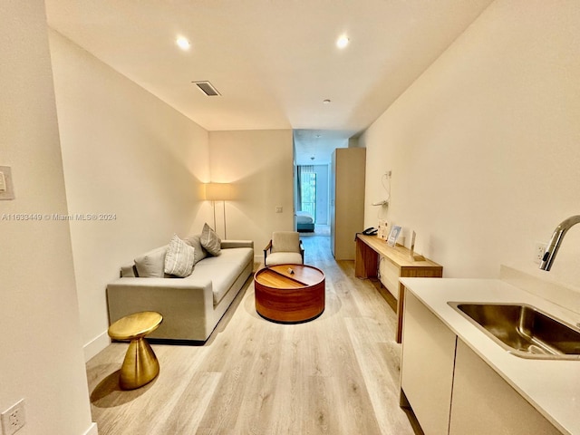 living room featuring sink and light hardwood / wood-style floors