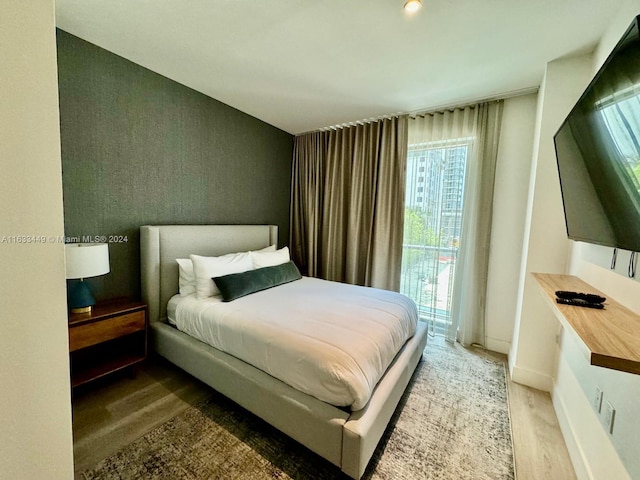 bedroom with access to outside and wood-type flooring