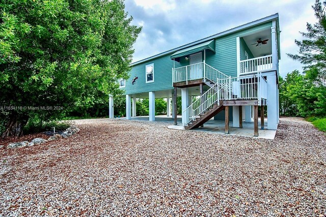 rear view of property featuring ceiling fan and a patio area