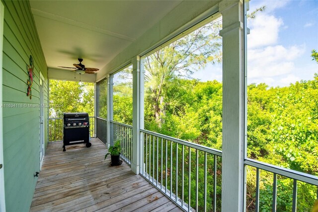 wooden deck with grilling area and ceiling fan