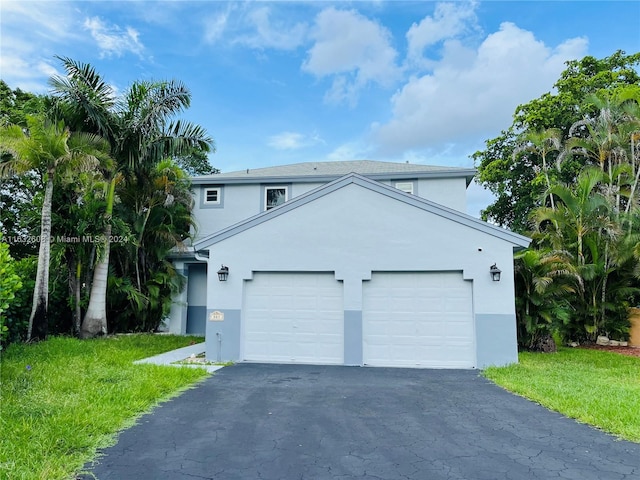 view of front of property featuring a front lawn and a garage