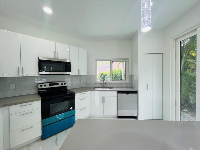 kitchen with tasteful backsplash, sink, white cabinets, and stainless steel appliances