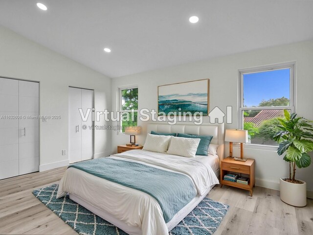 unfurnished bedroom featuring light wood-type flooring, ensuite bath, and vaulted ceiling