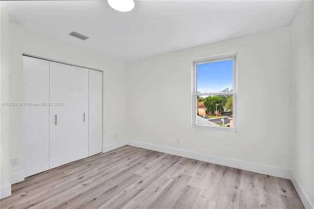 unfurnished bedroom featuring a closet and light hardwood / wood-style floors