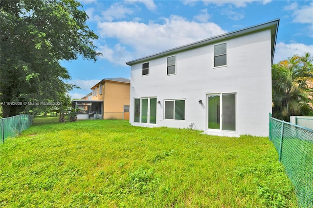 rear view of property featuring a yard