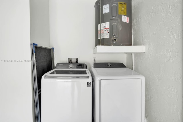 clothes washing area featuring washer and clothes dryer and water heater