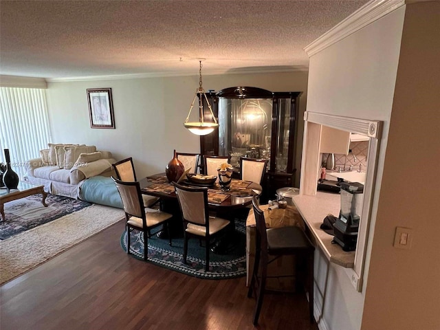 dining space with a textured ceiling, ornamental molding, and wood-type flooring