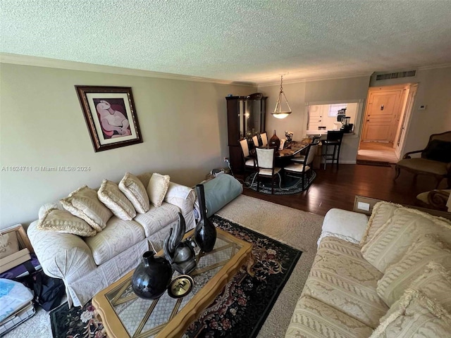 living room with a textured ceiling, ornamental molding, and wood-type flooring