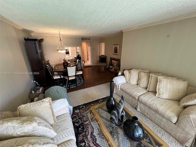 living room featuring wood-type flooring, crown molding, and a textured ceiling