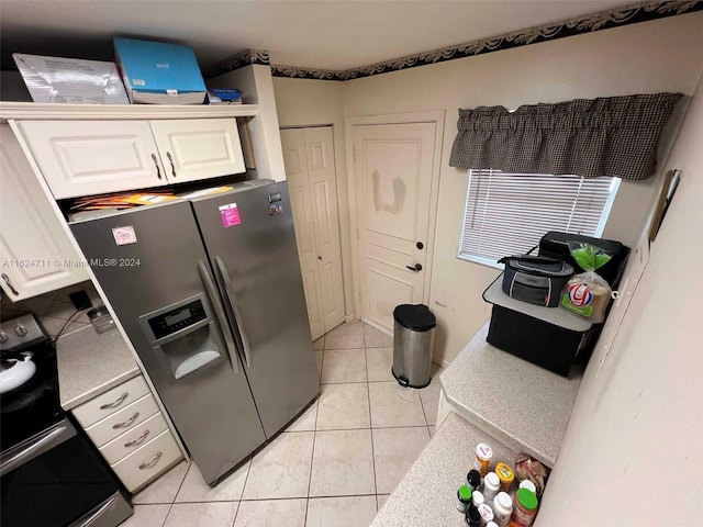 kitchen featuring stainless steel fridge with ice dispenser, white cabinetry, electric range oven, and light tile patterned floors