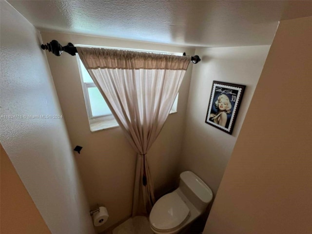 bathroom featuring toilet and a textured ceiling