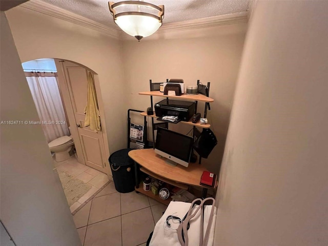 tiled home office with ornamental molding and a textured ceiling