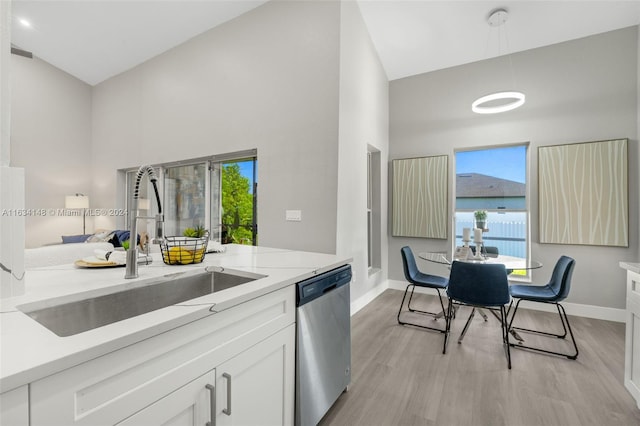 kitchen featuring sink, dishwasher, light hardwood / wood-style flooring, and white cabinets