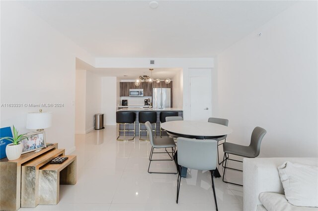 dining area featuring a chandelier and light tile patterned floors