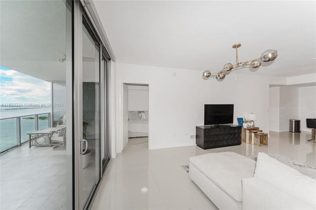 living room featuring light tile patterned flooring, a water view, and expansive windows