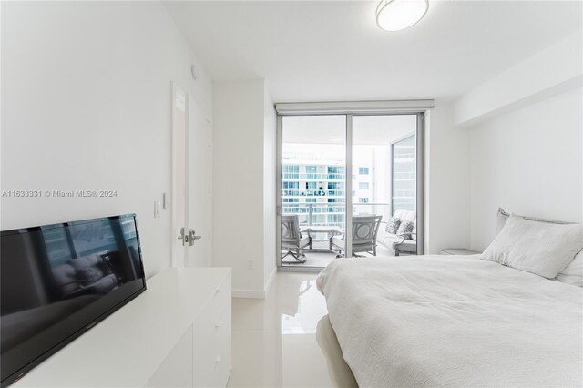 bedroom with a wall of windows and tile patterned flooring