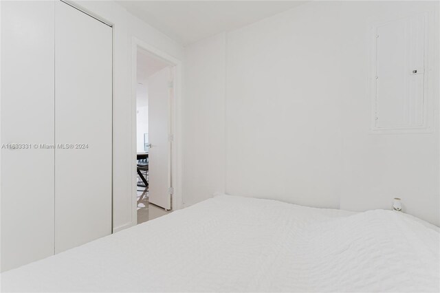 bedroom with electric panel and hardwood / wood-style flooring