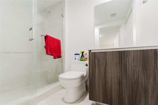 bathroom with tile patterned floors, a shower with door, and toilet