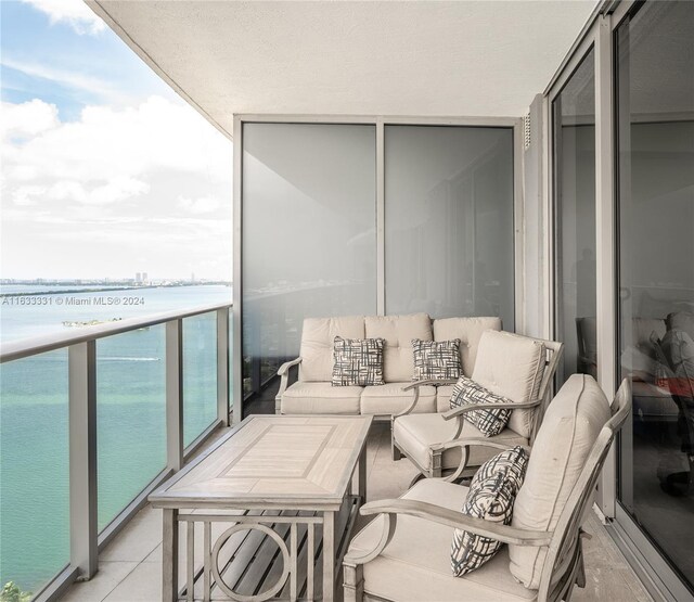 balcony featuring a water view and an outdoor living space