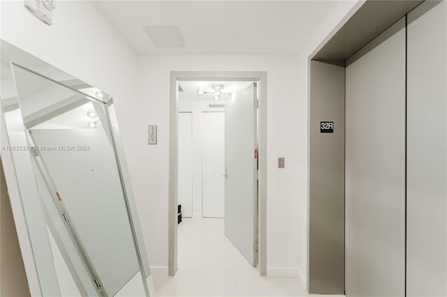 corridor with light tile patterned flooring and elevator