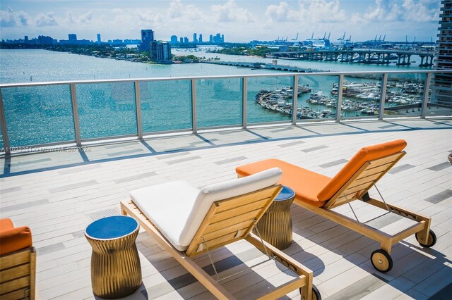 view of patio with a balcony and a water view