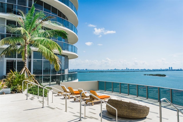 view of patio / terrace with a balcony and a water view