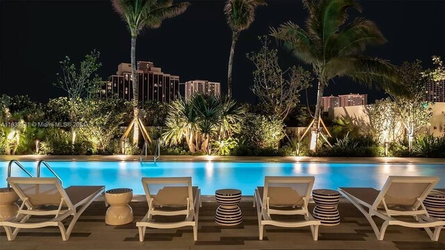 pool at twilight featuring a patio