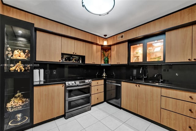 kitchen featuring sink, light tile patterned floors, double oven range, black dishwasher, and backsplash