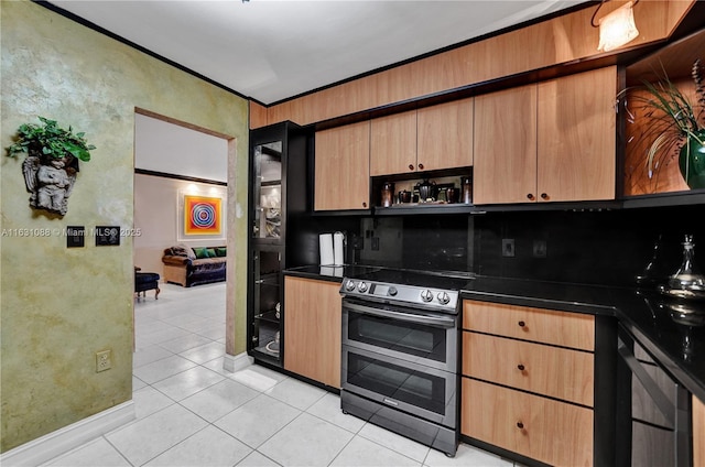 kitchen featuring double oven range, light tile patterned flooring, and crown molding