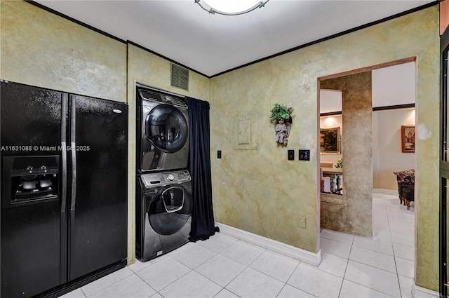 clothes washing area with stacked washer and dryer, light tile patterned flooring, and crown molding