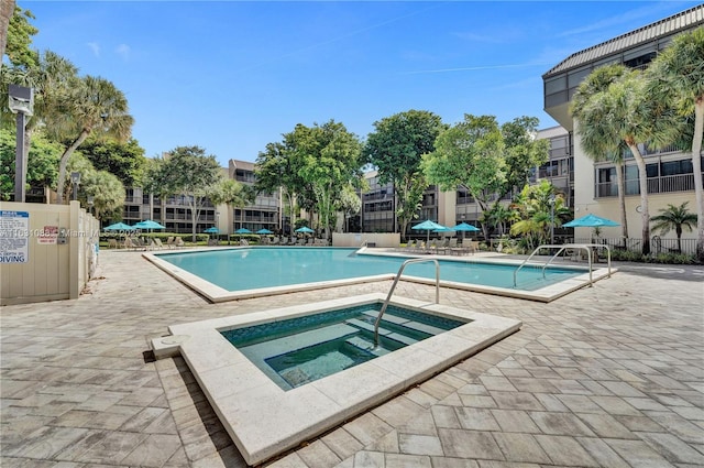 view of swimming pool with a patio and a community hot tub