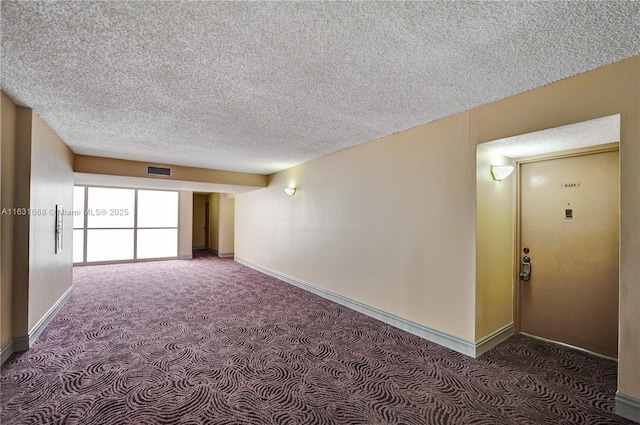 carpeted spare room featuring a textured ceiling