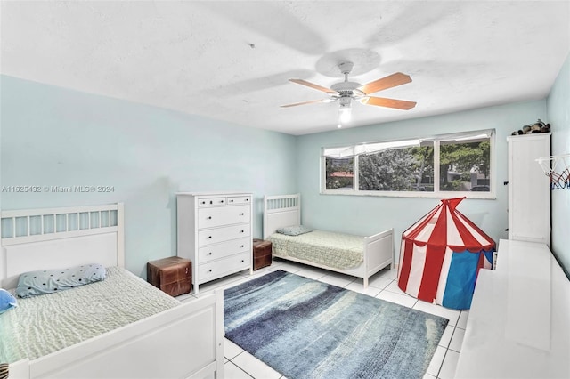 bedroom featuring a textured ceiling, ceiling fan, and light tile patterned flooring