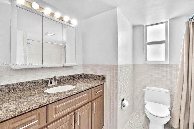 bathroom with vanity, tile walls, and toilet