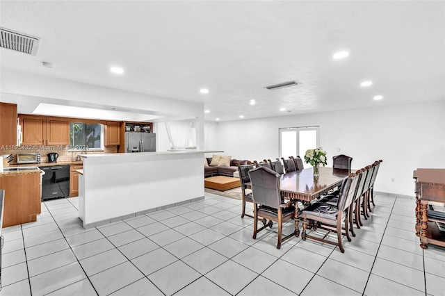 tiled dining room featuring a healthy amount of sunlight