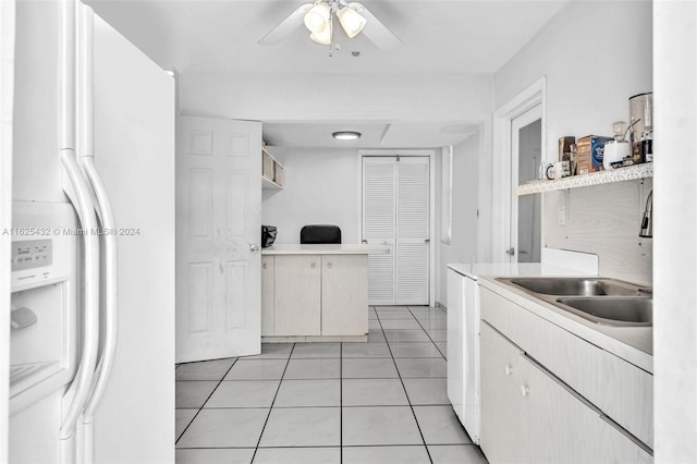 kitchen featuring ceiling fan, white refrigerator with ice dispenser, sink, and light tile patterned floors