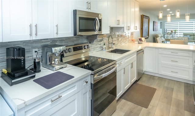 kitchen featuring sink, tasteful backsplash, light wood-type flooring, and stainless steel appliances