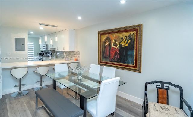 dining room with light hardwood / wood-style flooring and electric panel