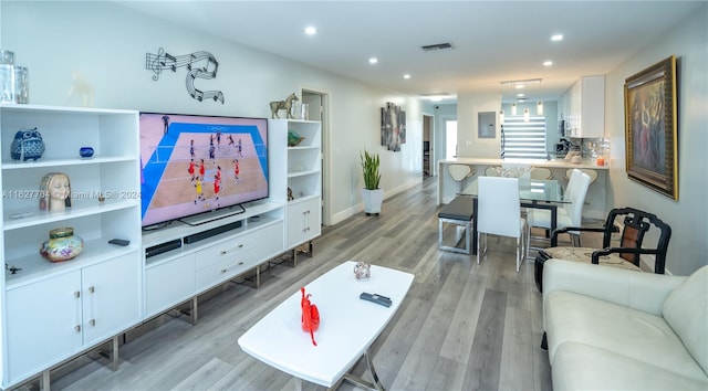 living room with light wood-type flooring and electric panel