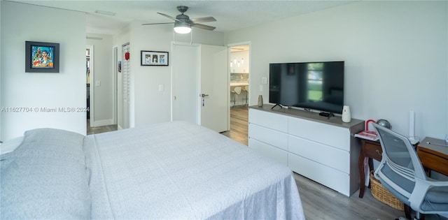 bedroom featuring hardwood / wood-style flooring, connected bathroom, and ceiling fan