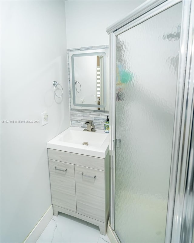 bathroom with vanity, an enclosed shower, tile patterned flooring, and backsplash