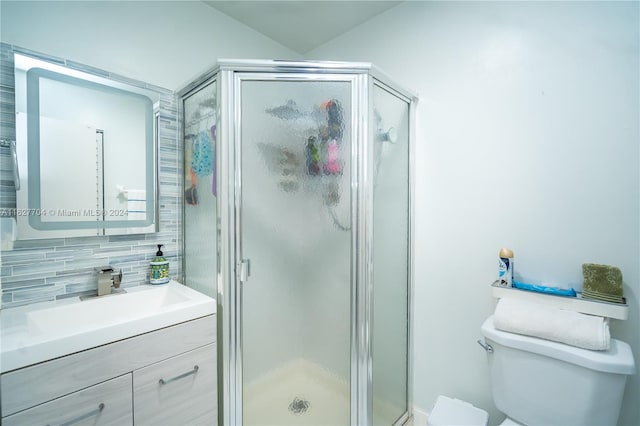 bathroom with vanity, backsplash, toilet, and an enclosed shower